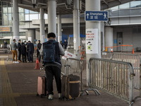 A man stands next to a sign pointing to Shenzhen in Shenzhen Bay Port on January 4, 2023 in Hong Kong, China. According to Local Media Repor...