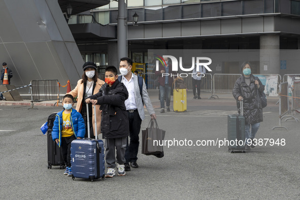 Travelers from China wearing face mask with luggages arrived in Shenzhen Bay Port on January 4, 2023 in Hong Kong, China. According to Local...