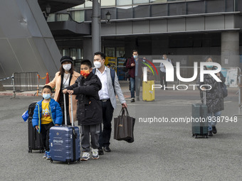 Travelers from China wearing face mask with luggages arrived in Shenzhen Bay Port on January 4, 2023 in Hong Kong, China. According to Local...