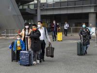 Travelers from China wearing face mask with luggages arrived in Shenzhen Bay Port on January 4, 2023 in Hong Kong, China. According to Local...