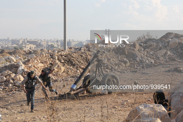 A Free Syrian Army fighter covers his ears as his fellow fighter fires a mortar shells towards the Sheikh Maqsud neighbourhood of the northe...