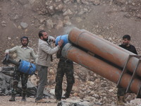 Free Syrian Army fighters prepare mortar shells towards the Sheikh Maqsud neighbourhood of the northern Syrian city of Aleppo on December 2,...