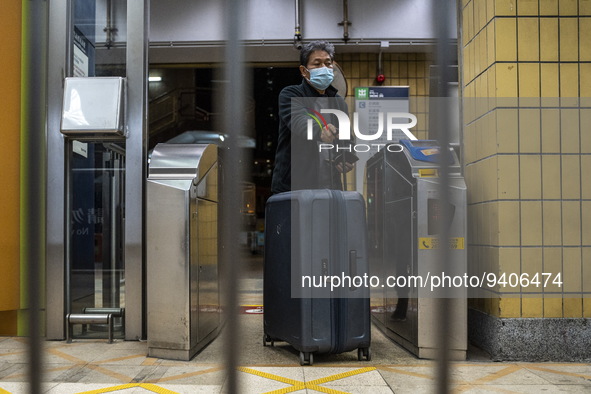 A man with a suitcase passing trough a gate to enter an MTR train platform for a train bound for Lok Ma Chau Control Point on January 8, 202...