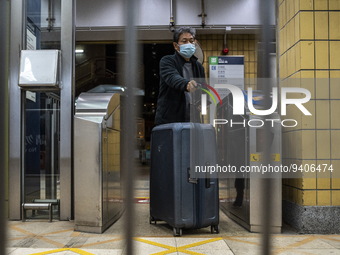 A man with a suitcase passing trough a gate to enter an MTR train platform for a train bound for Lok Ma Chau Control Point on January 8, 202...