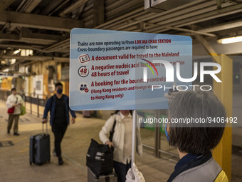 A worrier holding up a sign on requirement to cross at an MTR train platform for a train bound for Lok Ma Chau Control Point on January 8, 2...