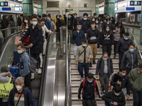 Travelers wearing face masks arriving at Lok Ma Chau Station on January 8, 2023 in Hong Kong, China. Hong Kong today resumes quarantine free...