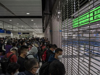 Travelers wearing face masks waiting for the gates to open at the Lok Ma Chau Border Crossing on January 8, 2023 in Hong Kong, China. Hong K...