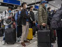 Travelers wearing face masks waiting for the gates to open at the Lok Ma Chau Border Crossing on January 8, 2023 in Hong Kong, China. Hong K...