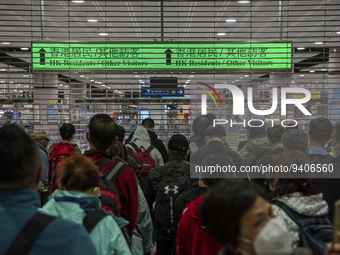 Travelers wearing face masks waiting for the gates to open at the Lok Ma Chau Border Crossing on January 8, 2023 in Hong Kong, China. Hong K...