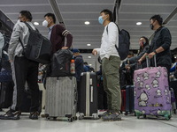 Travelers wearing face masks waiting for the gates to open at the Lok Ma Chau Border Crossing on January 8, 2023 in Hong Kong, China. Hong K...