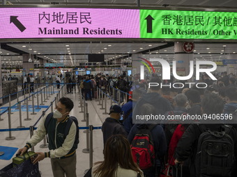 Travelers wearing face mask waiting in line to cross the border at the Lok Ma Chau Border Crossing on January 8, 2023 in Hong Kong, China. H...