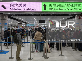 Travelers wearing face mask waiting in line to cross the border at the Lok Ma Chau Border Crossing on January 8, 2023 in Hong Kong, China. H...