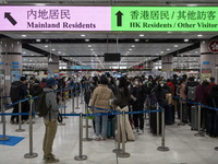 Travelers wearing face mask waiting in line to cross the border at the Lok Ma Chau Border Crossing on January 8, 2023 in Hong Kong, China. H...