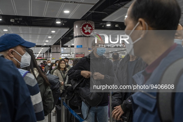 Travelers wearing face mask waiting in line to cross the border at the Lok Ma Chau Border Crossing on January 8, 2023 in Hong Kong, China. H...