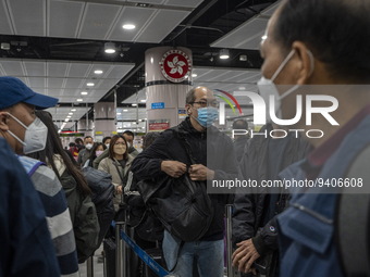 Travelers wearing face mask waiting in line to cross the border at the Lok Ma Chau Border Crossing on January 8, 2023 in Hong Kong, China. H...