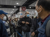 Travelers wearing face mask waiting in line to cross the border at the Lok Ma Chau Border Crossing on January 8, 2023 in Hong Kong, China. H...