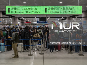 Travelers wearing face mask waiting in line to cross the border at the Lok Ma Chau Border Crossing on January 8, 2023 in Hong Kong, China. H...