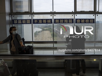 Travelers wearing face masks with suitcases crossing from Lok Ma Chau control point in Hong Kong to Futian Port in China on January 8, 2023...