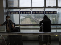 Travelers wearing face masks with suitcases crossing from Lok Ma Chau control point in Hong Kong to Futian Port in China on January 8, 2023...