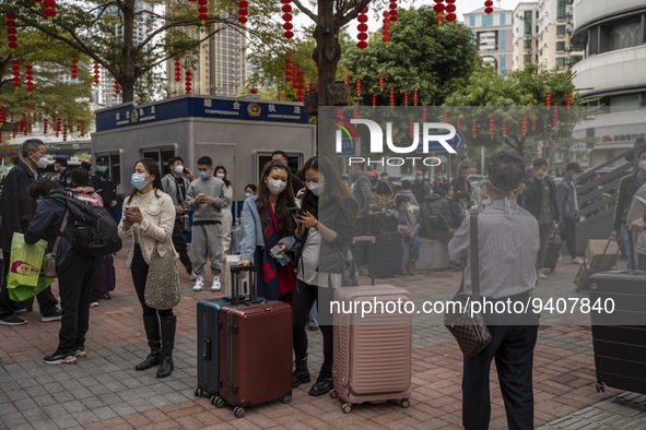 Travelers wearing face masks with suitcases outside Futian Port on January 8, 2023 in Shenzhen, China. Hong Kong today resumes quarantine fr...