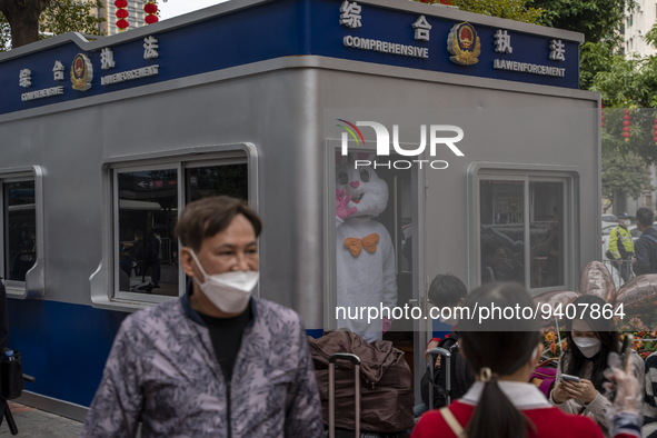 A worker dress in a rabbit costume standing inside a police post outside Futian Port on January 8, 2023 in Shenzhen, China. Hong Kong today...