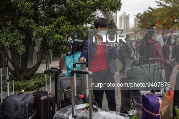 A women wearing a face mask with suitcases outside Futian Port on January 8, 2023 in Shenzhen, China. Hong Kong today resumes quarantine fre...