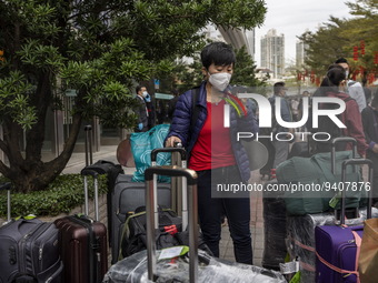 A women wearing a face mask with suitcases outside Futian Port on January 8, 2023 in Shenzhen, China. Hong Kong today resumes quarantine fre...