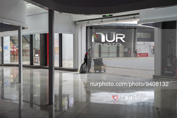 A delivery worker waiting at an entrance of a shopping center in Huaqiangbei, a popular place to buy electronic goods on January 8, 2023 in...