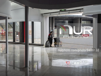 A delivery worker waiting at an entrance of a shopping center in Huaqiangbei, a popular place to buy electronic goods on January 8, 2023 in...