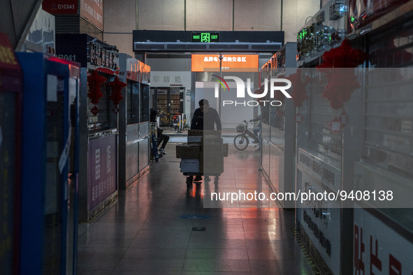 A worker pushing a cart next to closed store inside a shopping center in Huaqiangbei, a popular place to buy electronic goods on January 8,...