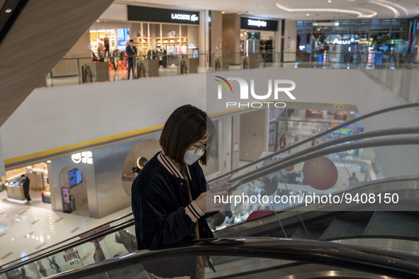 A women wearing a face mask riding an escalator inside a shopping mall on January 8, 2023 in Shenzhen, China. China today lifts its requirem...