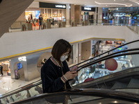 A women wearing a face mask riding an escalator inside a shopping mall on January 8, 2023 in Shenzhen, China. China today lifts its requirem...