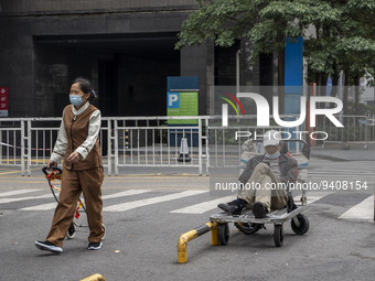 People wearing a face mask walking down a street on January 8, 2023 in Shenzhen, China. China today lifts its requirement for inbound travel...