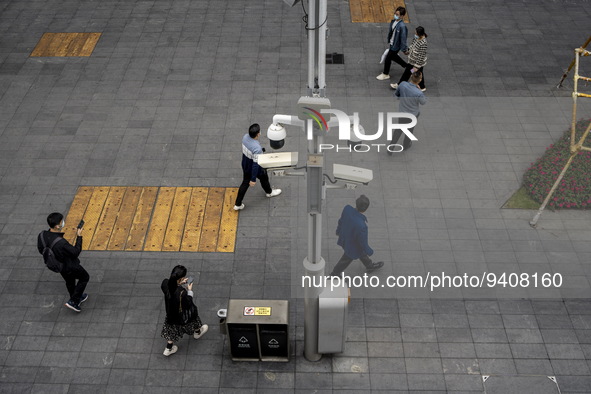 People walking pass security cameras on January 8, 2023 in Shenzhen, China. China today lifts its requirement for inbound travelers to under...