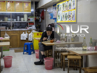 A man eating inside a restaurant on January 8, 2023 in Shenzhen, China. China today lifts its requirement for inbound travelers to undergo a...