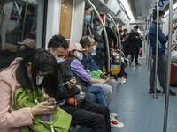 People wearing face masks riding on the metro on January 8, 2023 in Shenzhen, China. China today lifts its requirement for inbound travelers...