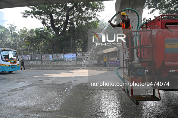 A worker spraying water on the street to control dust as the city's air quality in Dhaka, Bangladesh, on January 21, 2023 