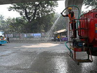 A worker spraying water on the street to control dust as the city's air quality in Dhaka, Bangladesh, on January 21, 2023 (