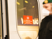 

A sign requiring masks is seen on a Deutsche Bahn ICE high-speed train at Cologne Central Station in Cologne, Germany on January 25, 2021,...