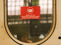 

A sign requiring masks is seen on a Deutsche Bahn ICE high-speed train at Cologne Central Station in Cologne, Germany on January 25, 2021,...