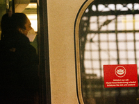 

A sign requiring masks is seen on a Deutsche Bahn ICE high-speed train at Cologne Central Station in Cologne, Germany on January 25, 2021,...