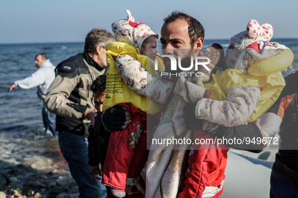 Volunteers help around 50 refugees and migrants to disembark from a vessel after their arrival from the Turkish coast to the northeastern Gr...