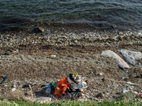 A women holds her child on a beach near to the town of Mytilene after crossing a part of the Aegean sea on a dinghy, with other refugees and...