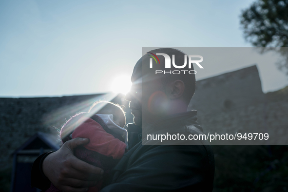 A man holds her child on a beach near to the town of Mytilene after crossing a part of the Aegean sea on a dinghy, with other refugees and m...