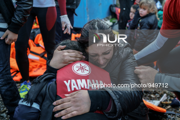 A woman cries while holding her child on a beach next to the town of Mytilene, shortly after crossing a part of the Aegean sea on a dinghy,...