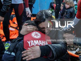 A woman cries while holding her child on a beach next to the town of Mytilene, shortly after crossing a part of the Aegean sea on a dinghy,...