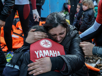 A woman cries while holding her child on a beach next to the town of Mytilene, shortly after crossing a part of the Aegean sea on a dinghy,...