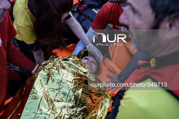 Spanish Lifeguards assists an injured woman lying on shore after she arrived with other migrants and refugees on the Greek island of Lesbos...