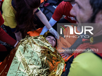 Spanish Lifeguards assists an injured woman lying on shore after she arrived with other migrants and refugees on the Greek island of Lesbos...