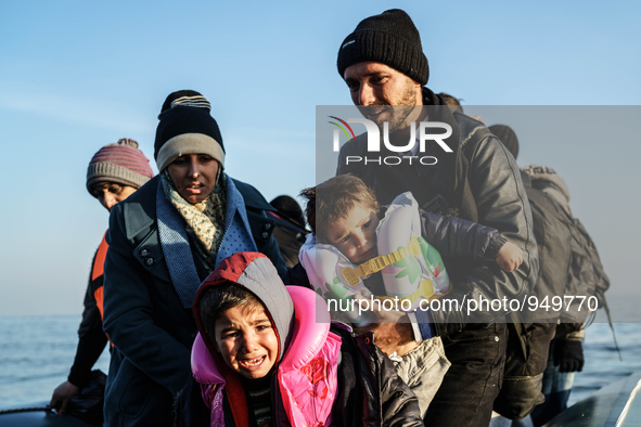 Refugees and migrants aboard a dinghy approach the northeastern Greek island of Lesbos after traveling from the Turkish coast  Dec. 8, 2015....